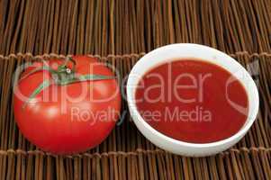 tomato and bowl of tomato sauce