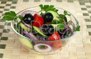 salad in a glass bowl on a wooden base