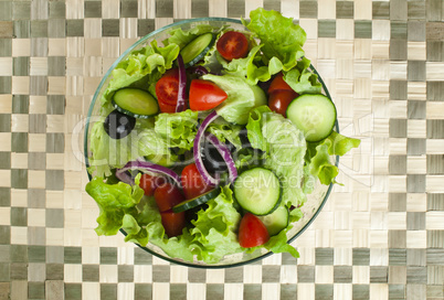 salad in a glass bowl on a wooden base