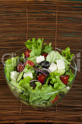 salad in a glass bowl on a wooden base