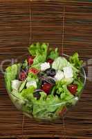 salad in a glass bowl on a wooden base