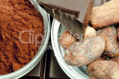 cocoa beans, cocoa powder in bowls and chocolate bar