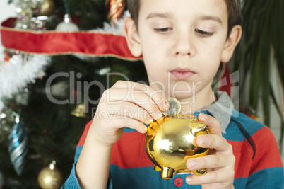 little boy puts a coin in cash pig