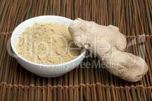 powdered ginger in a bowl and whole ginger