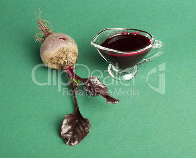 red beets with leaves and jug with juice