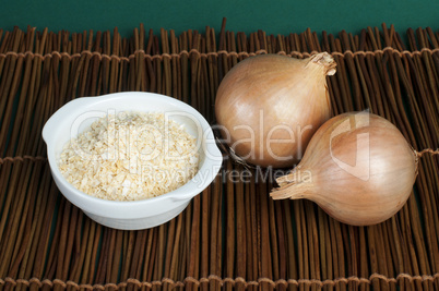 mature onion and bowl with dried onion powder
