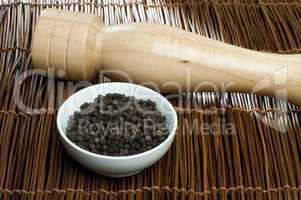bowl with black pepper and wooden pepper mill