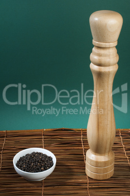 bowl with black pepper and wooden pepper mill