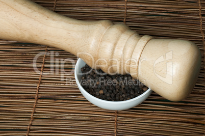 bowl with black pepper and wooden pepper mill