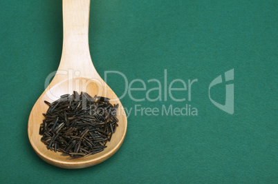 wild black rice in wooden spoon