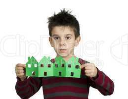 little boy holding houses made ??of paper