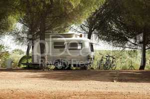 small white caravan through the trees