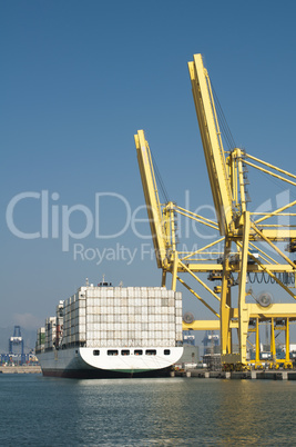 freighter in port being loaded with containers