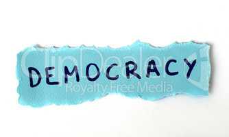 The word Democracy on blue paper