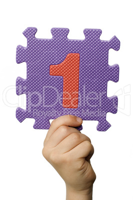 Children hand holding the number One. White isolated number