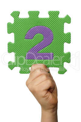 Children hand holding the number Two. White isolated number