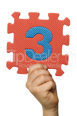 Children hand holding the number Three. White isolated number