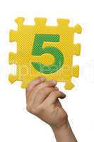Children hand holding the number Five. White isolated number