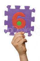 Children hand holding the number Six. White isolated number