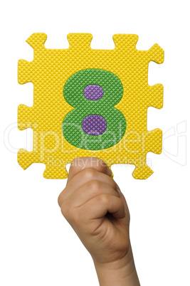Children hand holding the number Eight. White isolated number