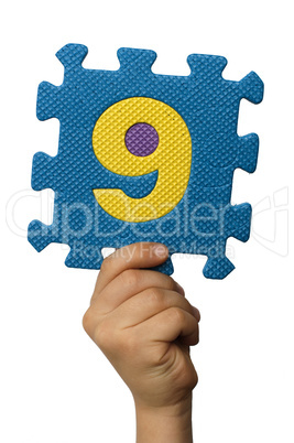 Children hand holding the number Nine. White isolated number