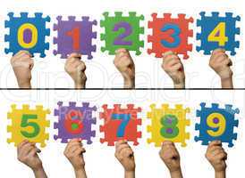 Children hands holding numbers. White isolated multicolor number