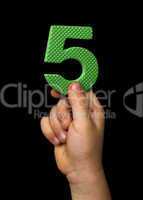 Children hand holding the number Five