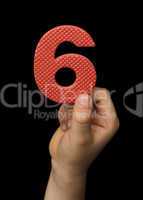 Children hand holding the number Six