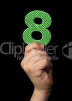 Children hand holding the number Eight