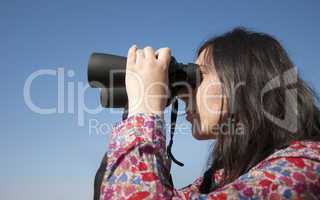 Young woman using binoculars
