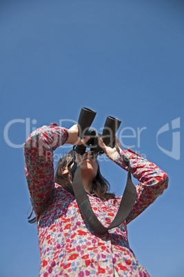 Young woman using binoculars