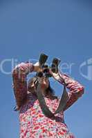 Young woman using binoculars