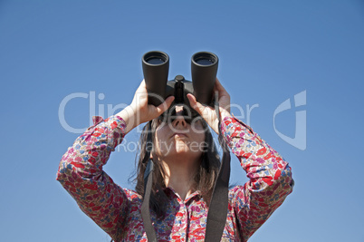 Young woman using binoculars