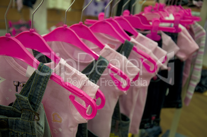 Clothes hang on hangers in shop