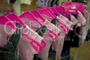 Clothes hang on hangers in shop