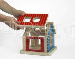 Boy hands and wood colorful house toy