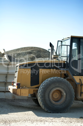 Excavator close-up and piles of sand