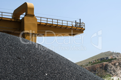 Asphalt pile and crane in quarry