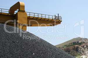 Asphalt pile and crane in quarry