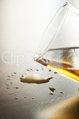 Glass with whiskey and drops on the table