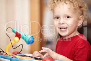 adorable little boy playing with a toy microphone