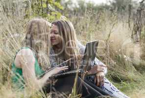 two women friends sitting outdoors together