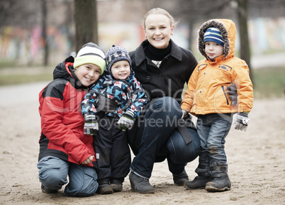 happy mother with her three young children