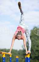 agile young gymnast balancing on cross bars
