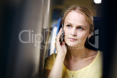 attractive woman listening to a call on her mobile travelling by train