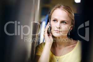 attractive woman listening to a call on her mobile travelling by train