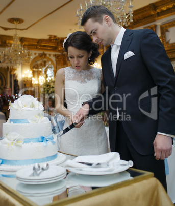 bride and groom making a wish as they cut the cake