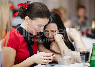 two stylish women at an event reading sms