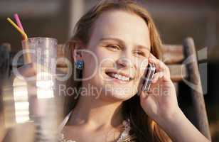 woman talking on her mobile drinking cocktail and smiling