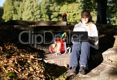 young woman working outdoors on a laptop